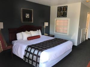 a bedroom with a large bed with a red pillow on it at Ouachita Mountain Inn in Glenwood