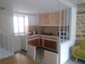 a kitchen with wooden cabinets and a table and a window at Les Mistinguettes in Pouzauges +10 photos