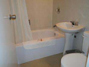 a bathroom with a sink and a tub and a toilet at St. Norbert Hotel in Winnipeg