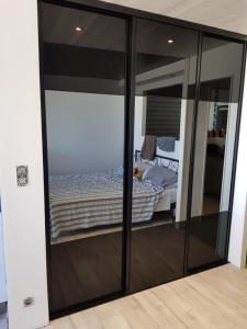 - une chambre avec des portes coulissantes en verre et un lit à l'intérieur dans l'établissement Studio Naturiste "AZUR" Héliopolis C 64, au Cap d'Agde