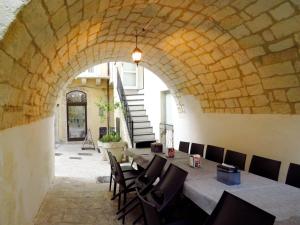 a dining room with a stone archway and a table and chairs at L'arco delle Commari in Ragusa