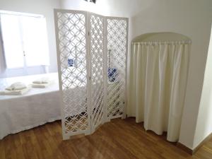 a white room with a bed and a mirror at L'arco delle Commari in Ragusa +64 photos