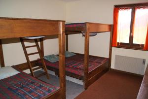 a room with two bunk beds and a window at Hotel Restaurant du Crêt in Bourg-Saint-Pierre