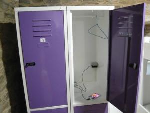 un armario púrpura y blanco con una puerta de cristal en Albergue El Paso, en Vega de Valcarce