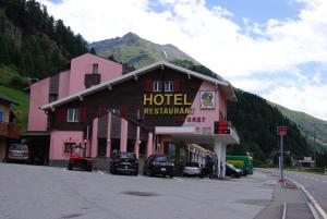 un hotel con auto parcheggiate di fronte a un edificio di Hotel Restaurant du Crêt a Bourg-Saint-Pierre