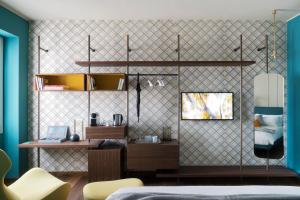 ミラノにあるCastello Sforzesco Suites by Brera Apartmentsのベッドとデスクが備わる壁の客室です。