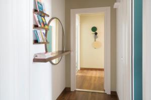 a hallway with a mirror and a shelf with books at Castello Sforzesco Suites by Brera Apartments in Milan +7 photos