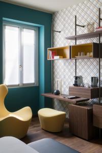 a room with a yellow chair and a desk at Castello Sforzesco Suites by Brera Apartments in Milan