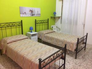 two beds in a room with green walls at Casa Alieta in Torre Lapillo