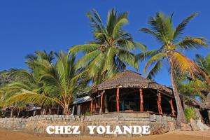 - un bâtiment sur la plage avec des palmiers dans l'établissement Chez Yolande, à Ampangorinana