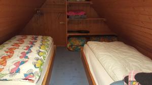 Zimmer mit 2 Betten und Regalen im Dachgeschoss in der Unterkunft Uns lütt Hus in Krakow am See