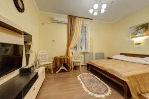 1 dormitorio con 1 cama y TV de pantalla plana en Aleksandria Hotel, en Kiev