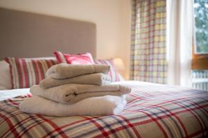 a stack of towels sitting on a bed at Paddock Cottage in Newport