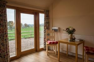 una camera con tavolo e porta scorrevole in vetro di Paddock Cottage a Newport Altre 7 foto