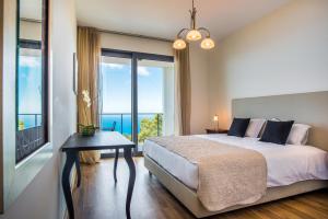 ein Schlafzimmer mit einem Bett und einem großen Fenster in der Unterkunft Villa Enjoy - by LovelyStay in Lombo da Velha