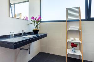 ein Badezimmer mit Waschbecken und Spiegel in der Unterkunft Villa Enjoy - by LovelyStay in Lombo da Velha + 16 Fotos