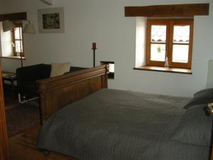 ein Schlafzimmer mit einem Bett, einem Stuhl und einem Fenster in der Unterkunft Auberge BRIASSOU in Grazac