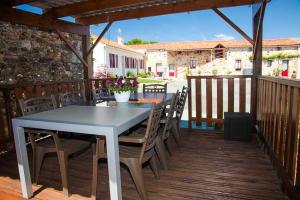 a table and chairs on a wooden deck at Domaine de La Courillère in Le Boupère