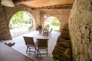 a patio with a table and chairs in a stone building at Le Clos Du Perret in Chaussan