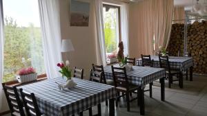 a dining room with two tables and chairs and a window at Gosciniec Wydminy in Wydminy