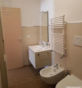 a bathroom with a sink and a toilet and a mirror at Case Vacanza Marzano in Monopoli