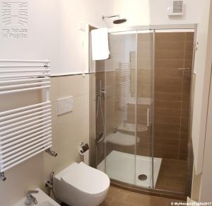 a bathroom with a toilet and a glass shower at Case Vacanza Marzano in Monopoli