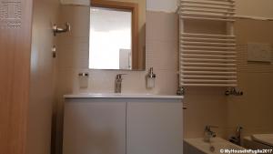 a bathroom with a white sink and a window at Case Vacanza Marzano in Monopoli