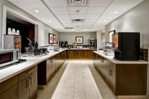 a large kitchen with wooden cabinets and a television at Canalta Hanna in Hanna