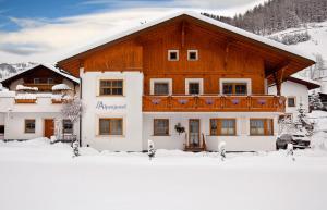 a large building with a balcony in the snow at Apart Alpenjuwel in Nauders