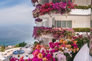 プエルト・バジャルタにあるGrand Miramar All Luxury Suites & Residencesの花の横の建物