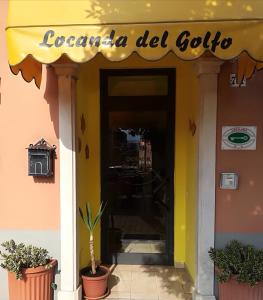 a restaurant with a yellow awning and a door at Locanda del Golfo in La Spezia