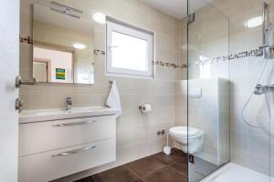 ein Badezimmer mit Dusche, Toilette und Waschbecken in der Unterkunft Olivea in Krk + 29 Fotos