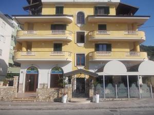 a large yellow building with two umbrellas in front of it at À La Maison De Gabry in Vibo Valentia Marina