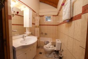a small bathroom with a sink and a toilet at Boulevard Panorama Suites in Agia Effimia