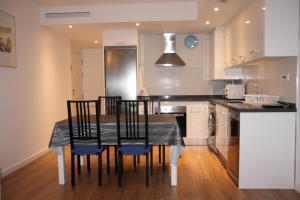 kuchnia z czarnym stołem i krzesłami w kuchni w obiekcie Apartamento Ribes Valencia w Walencji