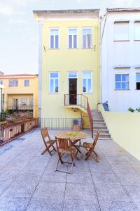 une terrasse avec une table et des chaises devant un bâtiment dans l'établissement Bright Sao Domingos Apartments, à Viana do Castelo