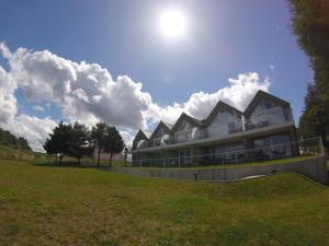 un grande edificio in un campo con il sole nel cielo di Apartament Vespa a Mechelinki