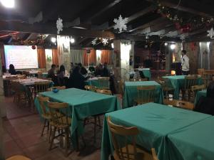 a group of people sitting at tables in a restaurant at Grappolo B&B affittacamere in Ascea