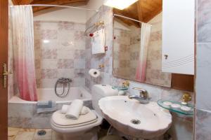 La salle de bains est pourvue d'un lavabo, de toilettes et d'une baignoire. dans l'établissement Boulevard Panorama Suites, à Agia Effimia