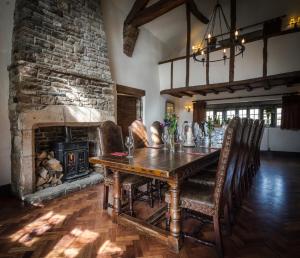 a dining room with a table and a fireplace at The Old Hall Inn in Chinley