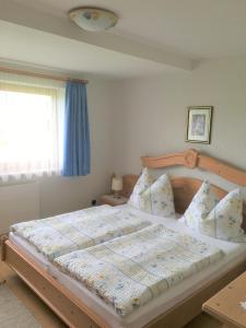 a large bed in a bedroom with a window at Appartements Michaela in Westendorf