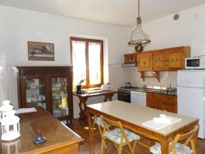 a kitchen with wooden cabinets and a table with chairs at Villa Patrizia in Torri del Benaco