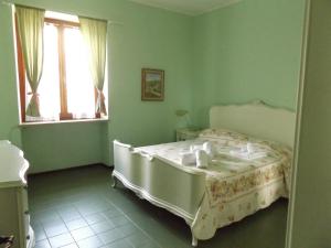 a bedroom with a white bed in a green room at Villa Patrizia in Torri del Benaco +30 photos