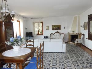 a living room with a white couch and a table at Villa Patrizia in Torri del Benaco