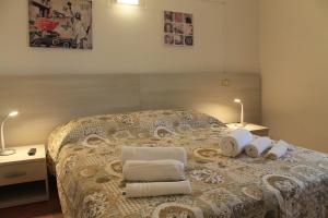- une chambre avec un lit, des serviettes et 2 lampes dans l'établissement Vacanze In Torre, à Rapolano Terme