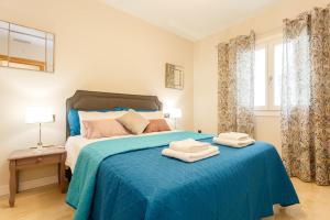 ein Schlafzimmer mit einem blauen Bett mit zwei Handtüchern darauf in der Unterkunft Apartamento El SABIO by Cadiz4Rentals in Cádiz