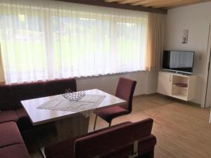 a living room with a table and chairs and a television at Appartements Michaela in Westendorf +43 photos