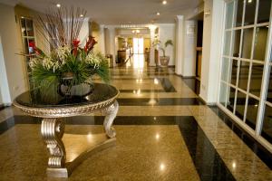 een lobby met een tafel met bloemen erop bij Hotel Parque Central in Monterrey