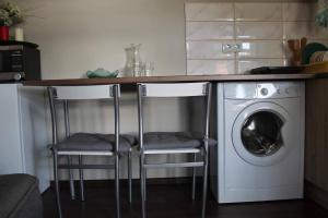 a kitchen with two bar stools and a washing machine at Soo 16 Apartment in Tallinn