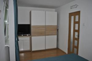 a bedroom with white cabinets and a flat screen tv at Apartament Freya in Constanţa